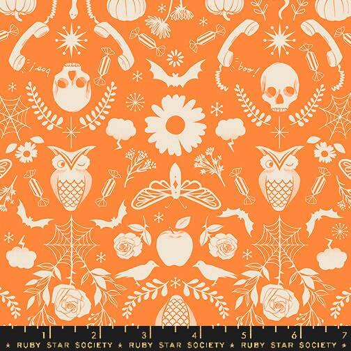 an orange and white pattern with skulls and flowers
