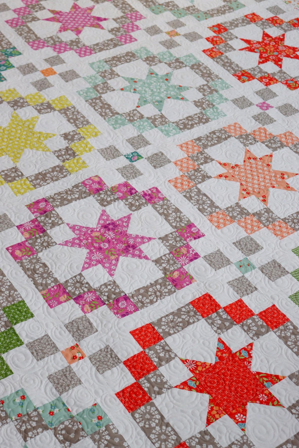 a quilted quilt with many different colored stars on it