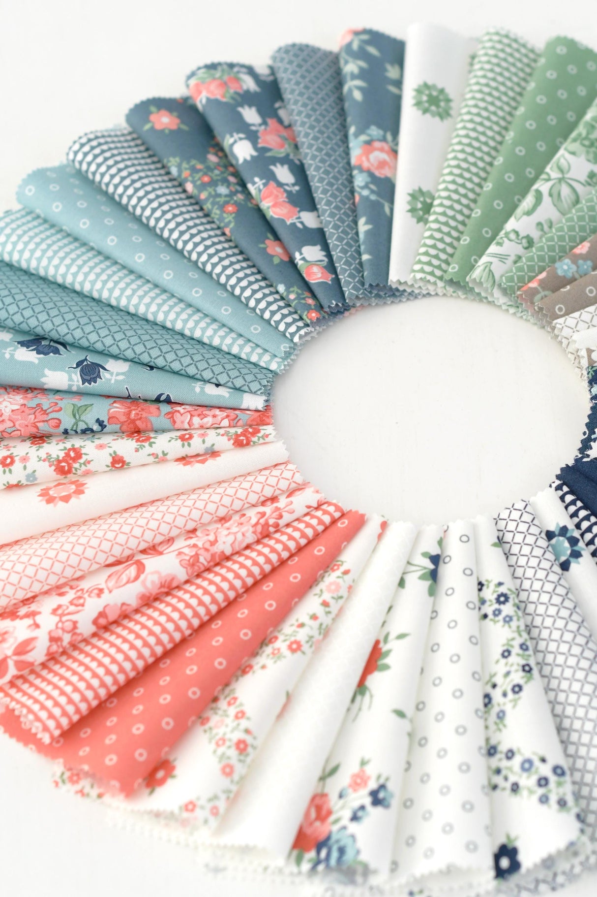 a circle of different colored fabrics on a white surface