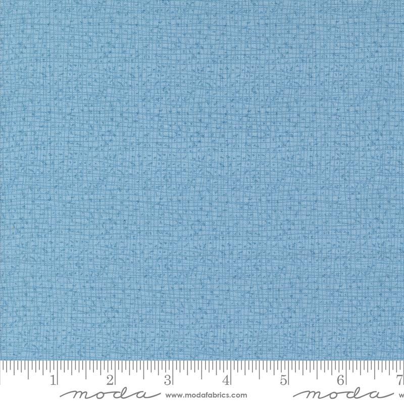 a blue fabric with a ruler in front of it