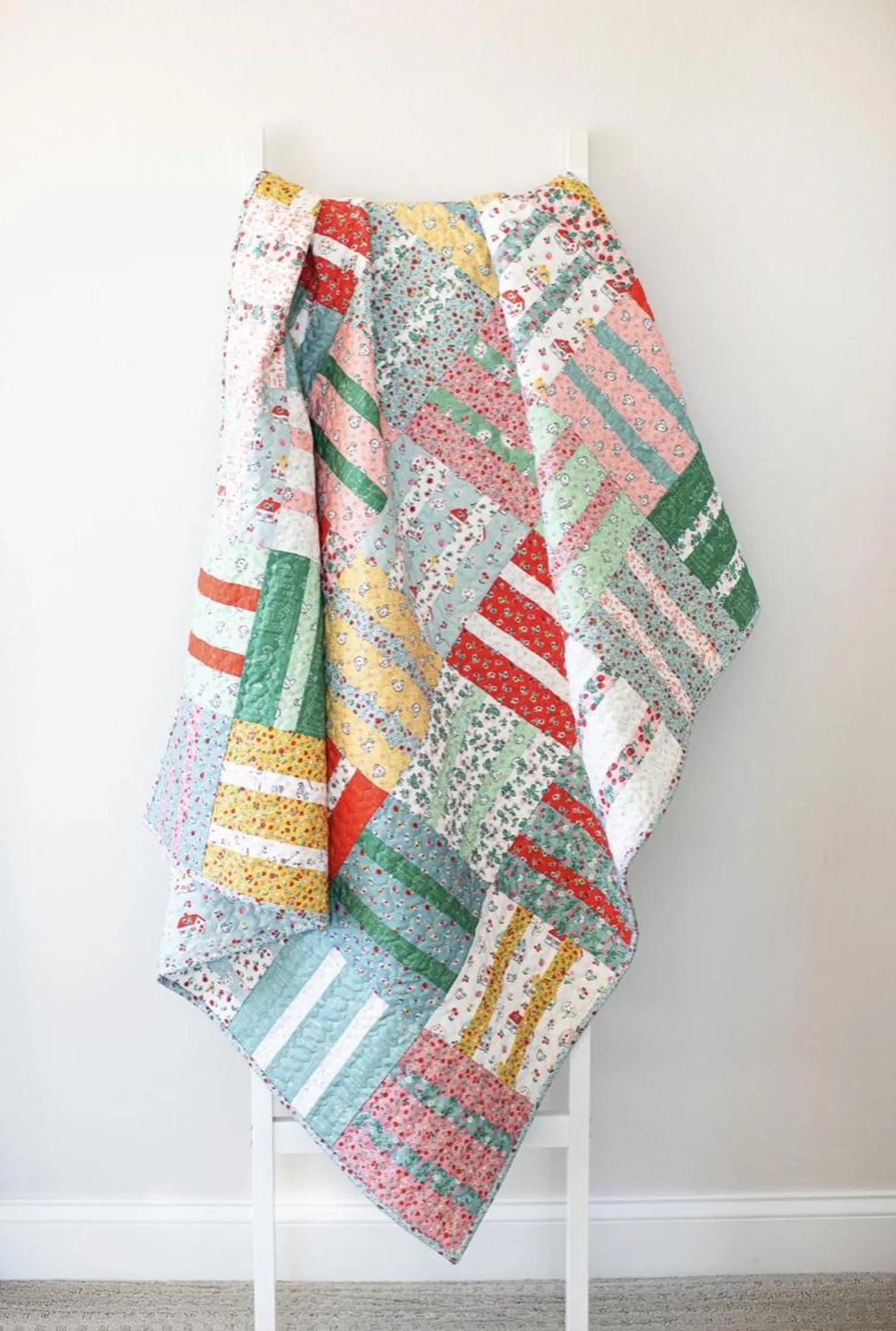 a multicolored quilt hanging on a wall