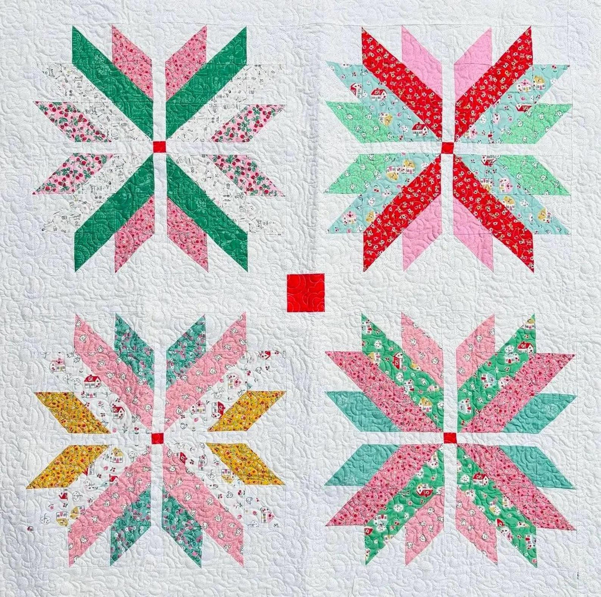 a quilted wall hanging with four snowflakes on it