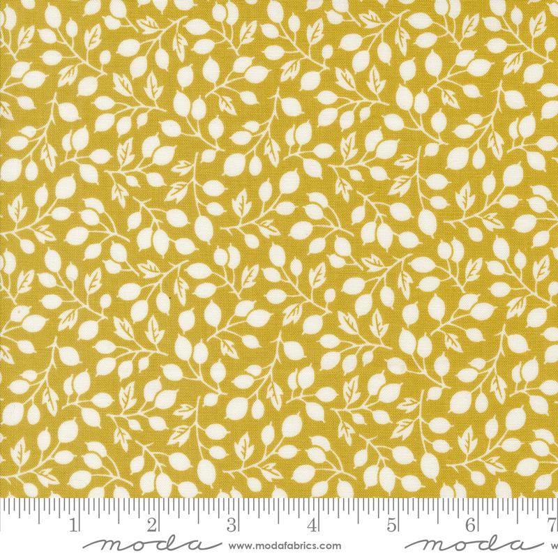 a yellow fabric with white leaves on it