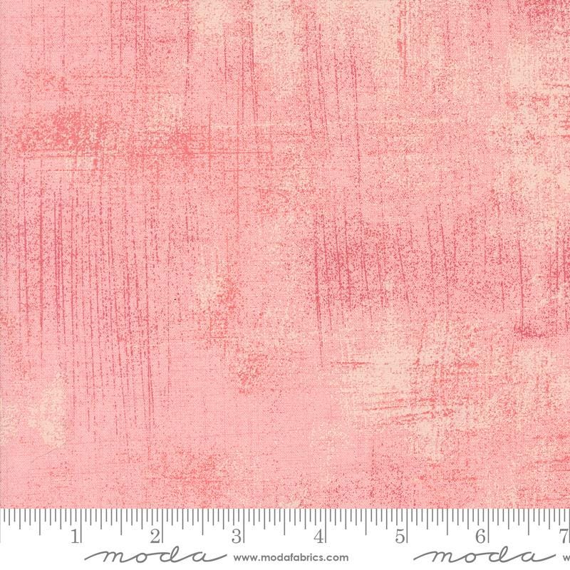 a pink background with a ruler in front of it