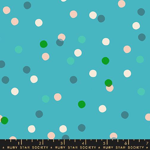 a ruler is next to a blue background with white and green polka dots