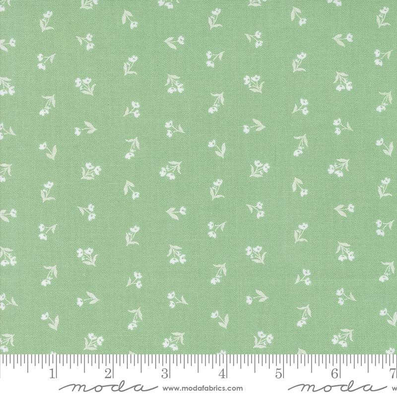 a green fabric with white flowers on it