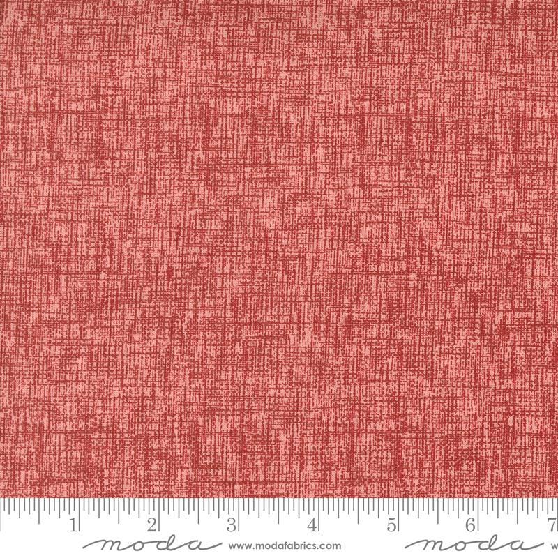 a red fabric with a ruler in front of it
