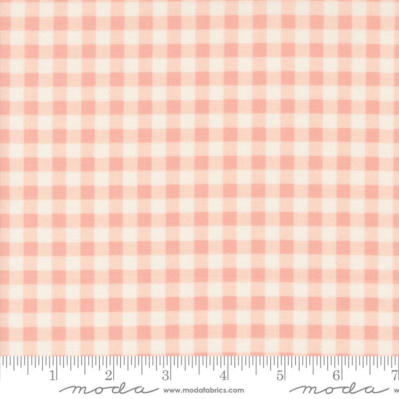 a pink and white checkered fabric with a ruler