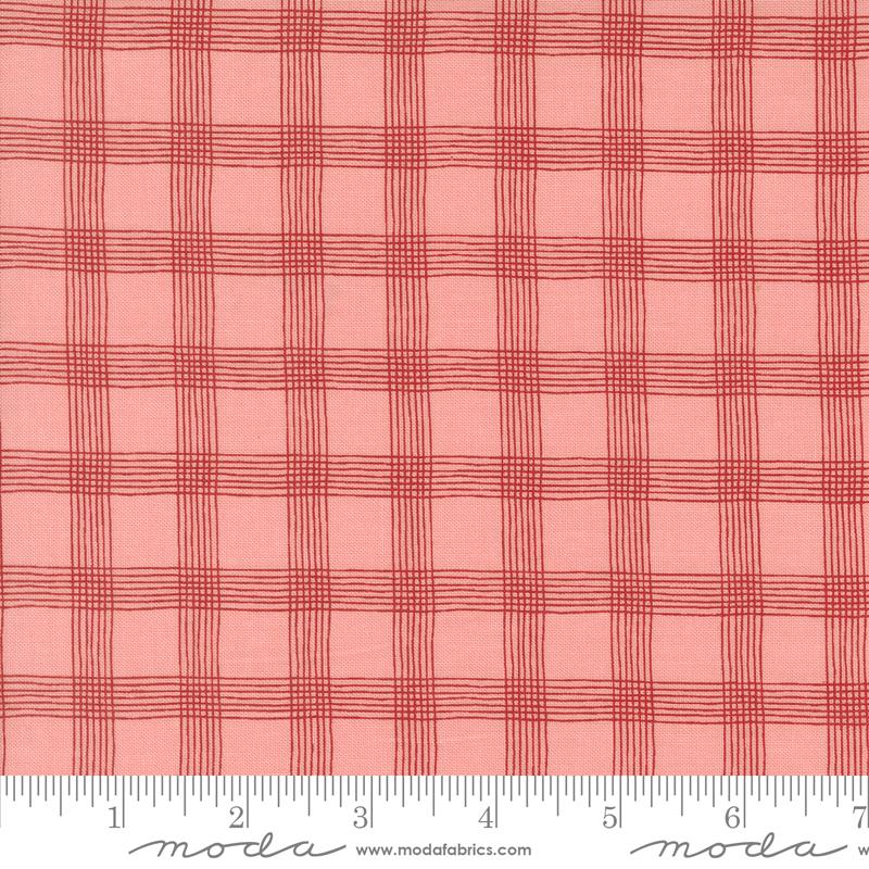 a red plaid fabric with a ruler in front of it