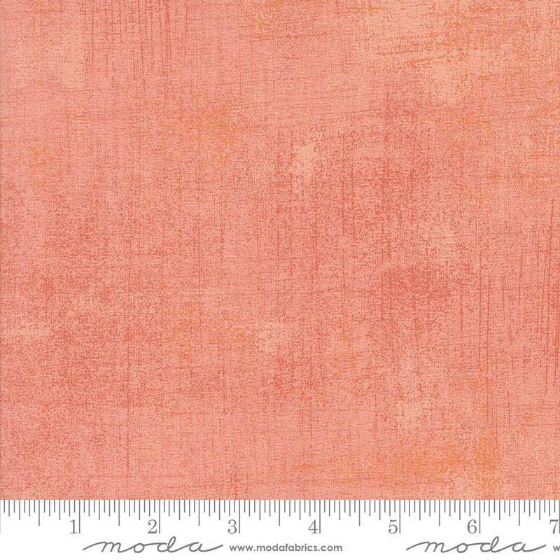The image is a close-up of a textured fabric with a gradient of peach and orange colors.