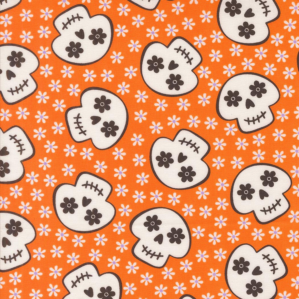 a repeating pattern of stylized skull faces on an orange background with white flowers.
