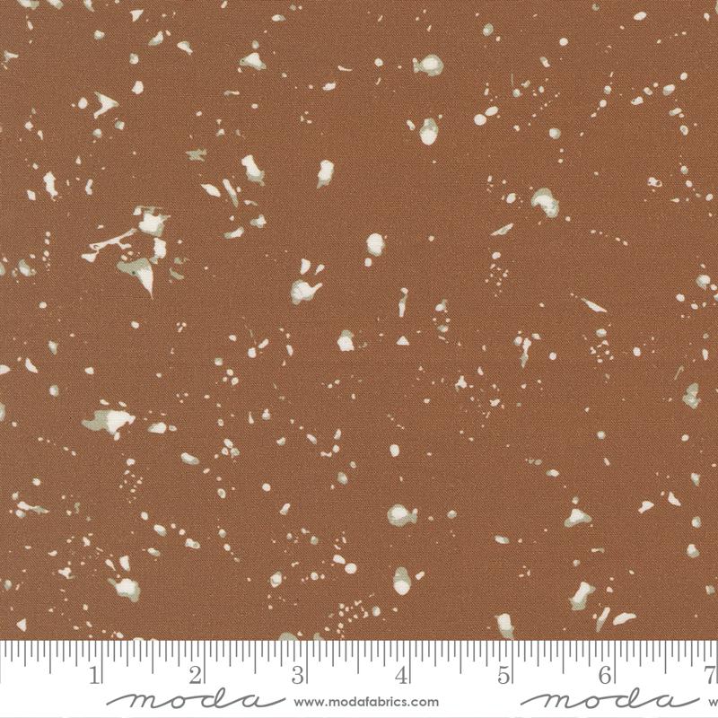 The image is a brown fabric with white speckles or dots scattered across it.