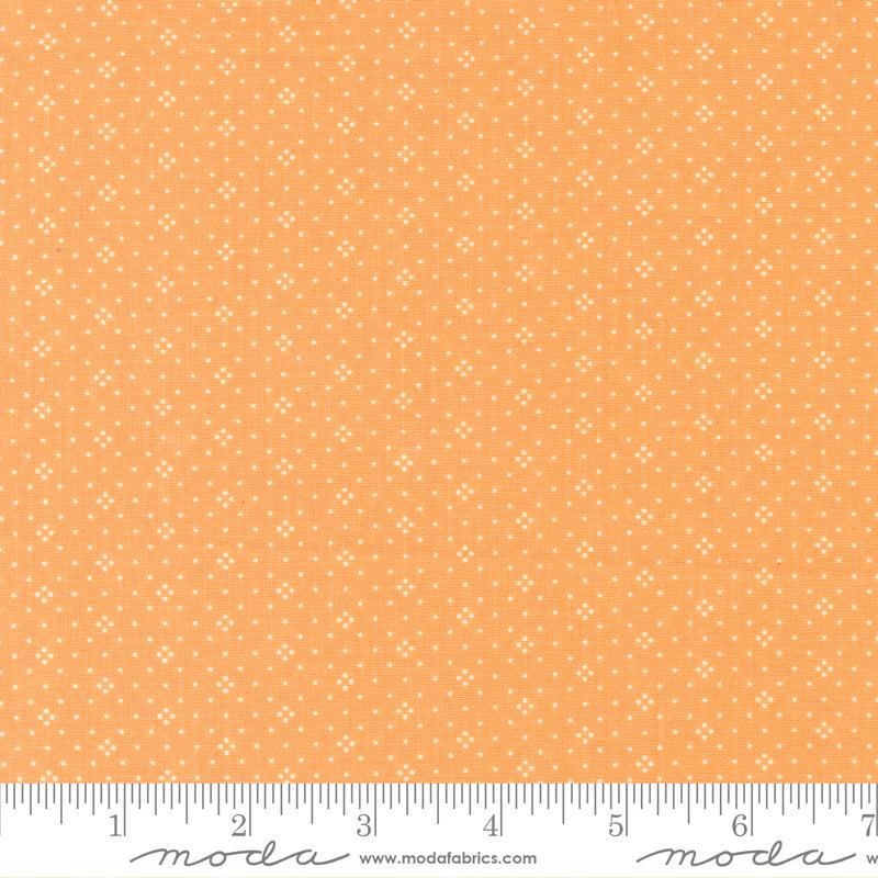 The image is a fabric with a repeating pattern of small white dots or stars on an orange background.