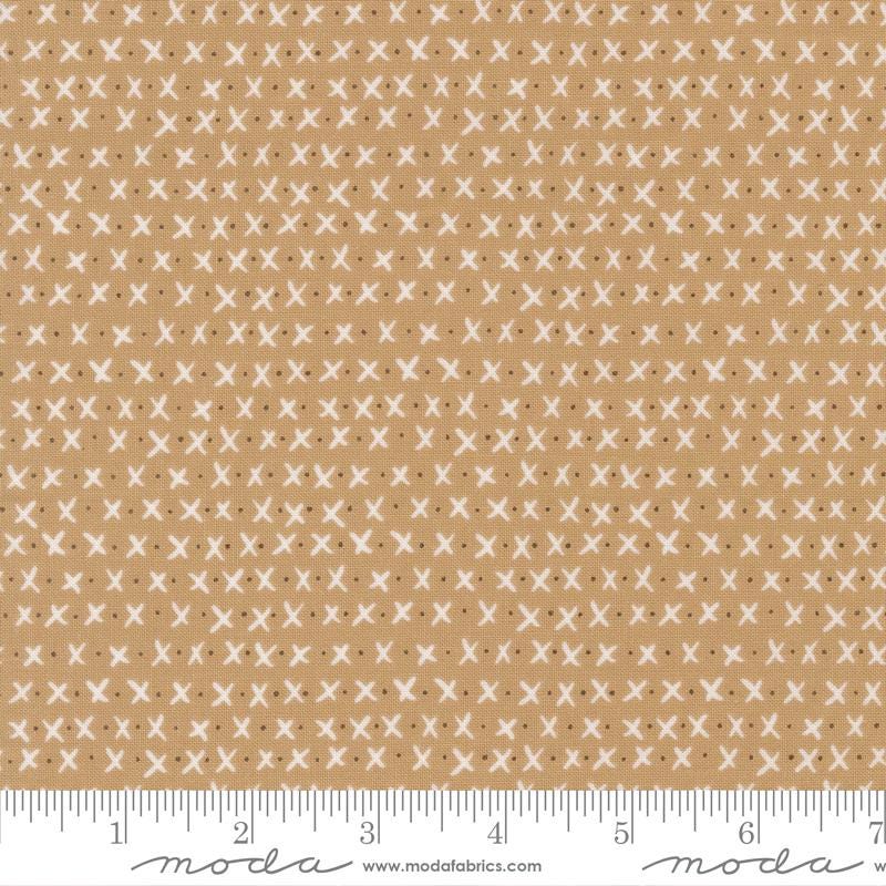 The image is a fabric with a repeating pattern of white crosses on a beige background.