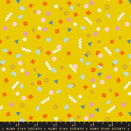 The image is a vibrant yellow background with various colorful shapes and patterns scattered across it, including stars, circles, triangles, and other geometric designs.