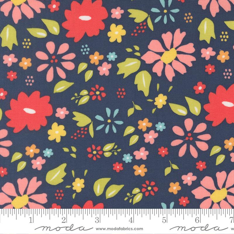 The image is a fabric with a floral pattern in shades of blue, pink, and yellow. The pattern consists of various flowers and leaves in different sizes and colors, creating a vibrant and lively design.
