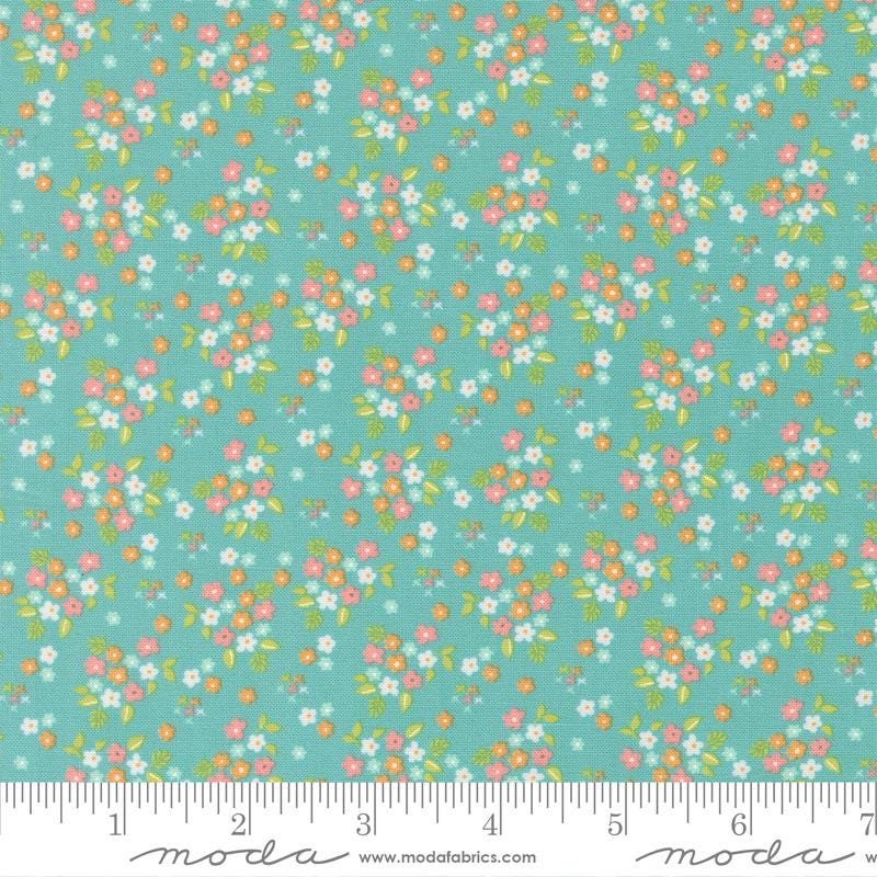 a fabric with a floral pattern in shades of green and pink. The pattern consists of small flowers and leaves scattered across the fabric, creating a vibrant and colorful design.