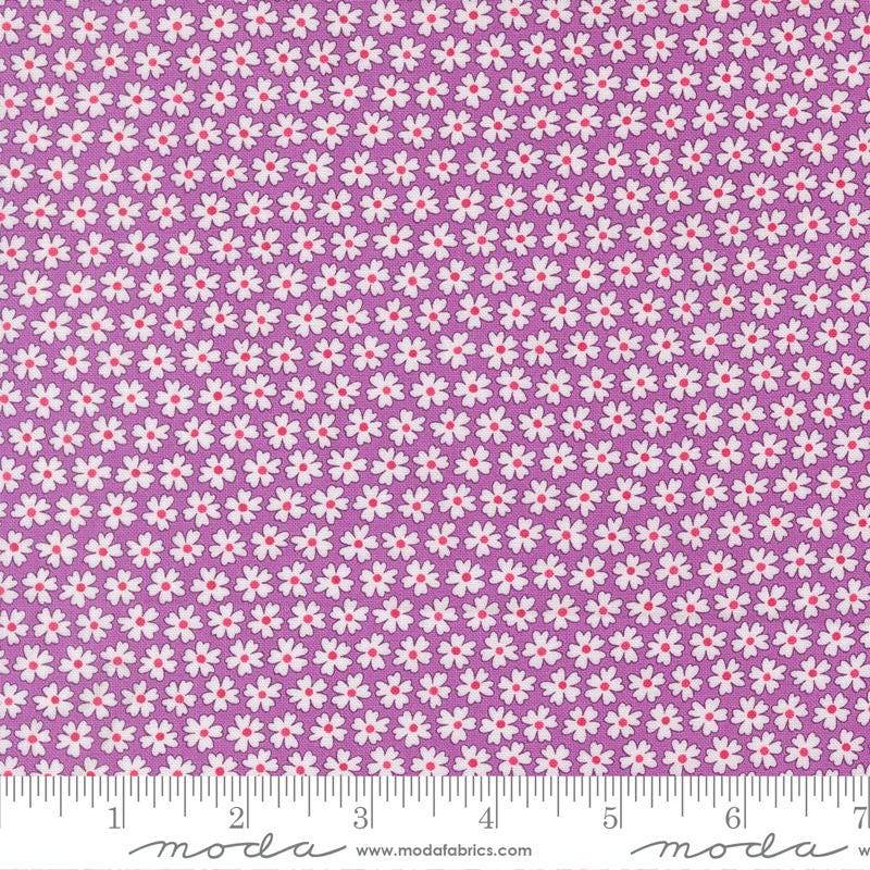 a fabric with a repeating pattern of white flowers on a purple background. The fabric appears to be a fabric with a floral pattern, and the image is described as a fabric with a floral pattern.