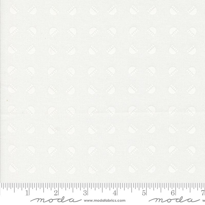 The image is a plain white fabric with a repeating pattern of circles or dots. There is a ruler at the bottom of the image for scale.