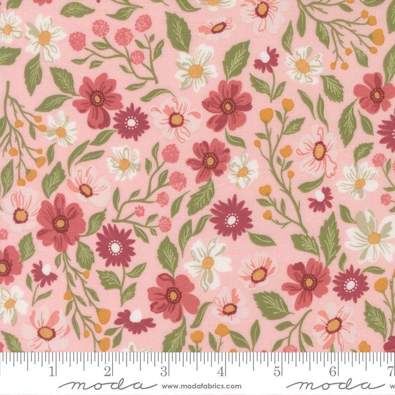 a fabric with a floral pattern in shades of pink and green. The pattern includes various types of flowers and leaves, creating a visually appealing and vibrant design.
