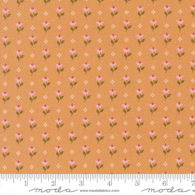 a repeating pattern of small pink flowers on an orange background, with a ruler for scale at the bottom.
