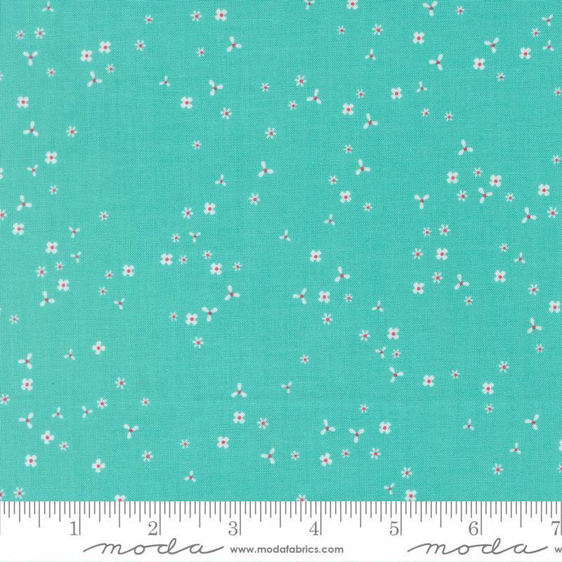 The image is a fabric with a teal green background and small white flowers scattered across it.