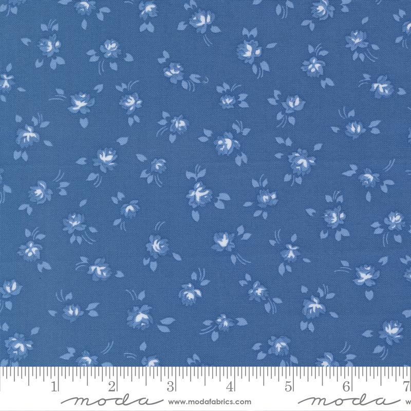 a fabric with a blue floral pattern, featuring small white flowers and leaves scattered across the fabric.