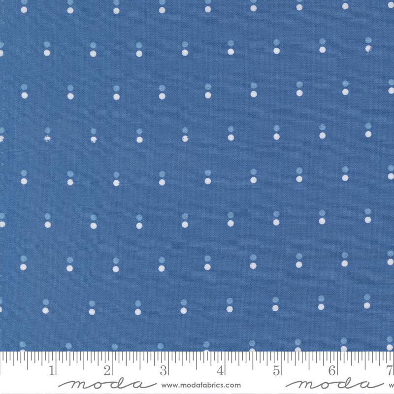 The image is a close-up of a blue fabric with white dots arranged in a diagonal pattern.