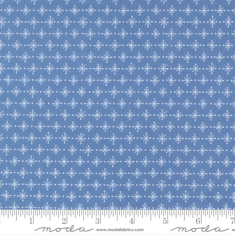 a blue fabric with a repeating pattern of white snowflakes. The fabric has a diagonal pattern of snowflakes, creating a visually appealing and festive design.