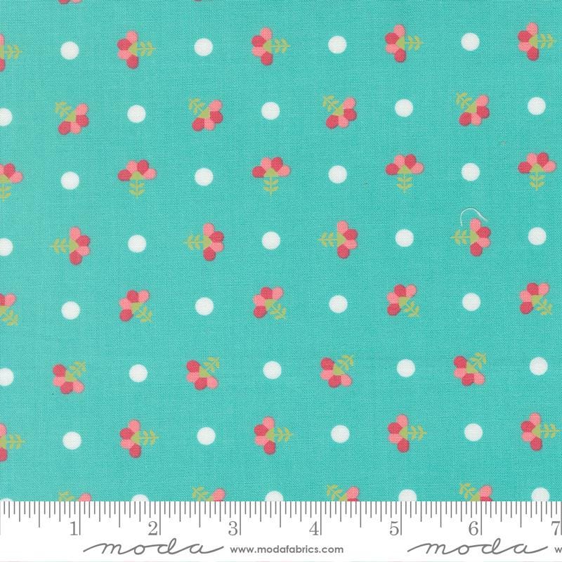 a fabric with a repeating pattern of small white dots and pink flowers on a turquoise background.