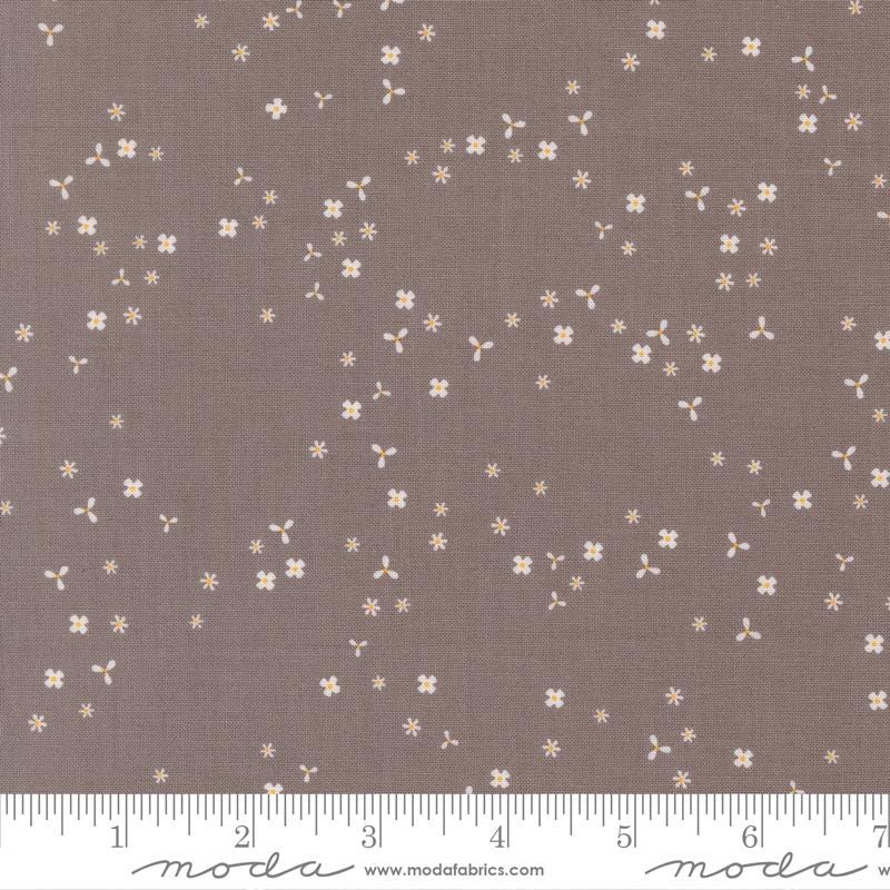 a brown fabric with small white flowers scattered across it.