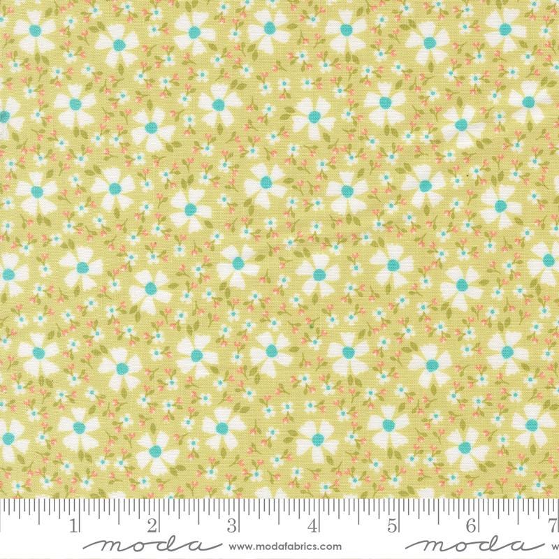 a fabric with a repeating pattern of white flowers with green centers against a yellow background. The fabric appears to be a soft, pastel-colored material, possibly cotton or linen.