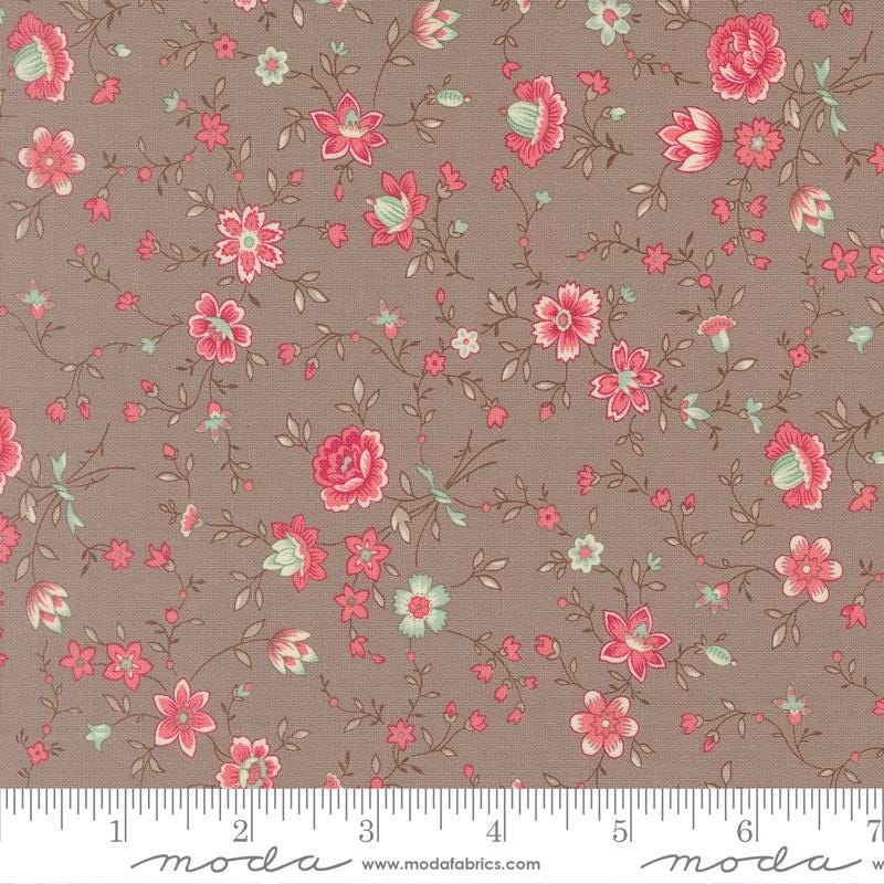 The image is a fabric with a floral pattern, featuring various pink and green flowers and leaves. The fabric appears to be a dark brown color, and there is a ruler at the bottom of the image for scale.