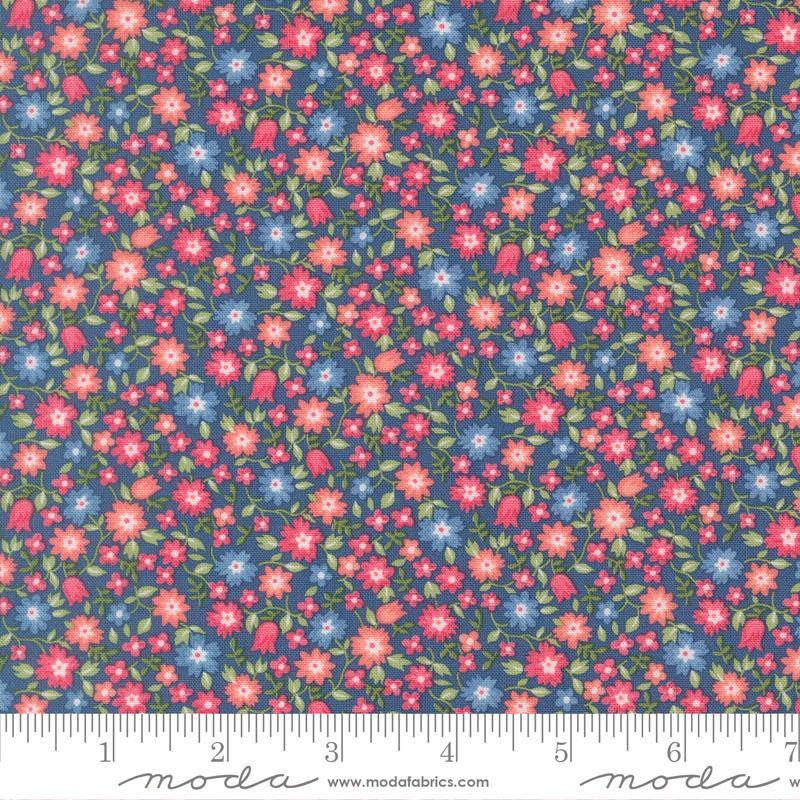 The image is a close-up of a fabric with a floral pattern, featuring small red, pink, and blue flowers scattered across a dark blue background.