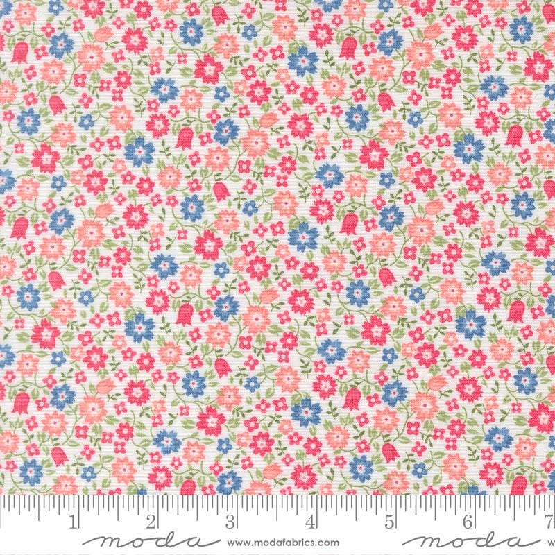 a fabric with a floral pattern in shades of pink, blue, and green. The fabric appears to be a light-colored material, possibly cotton or linen, with a repeating pattern of small flowers and leaves. The image does not contain any text or additional objects, and the focus is on the floral pattern.