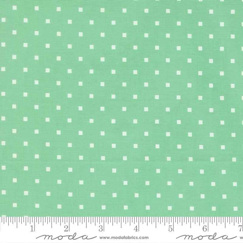 a fabric with a green background and white polka dots.