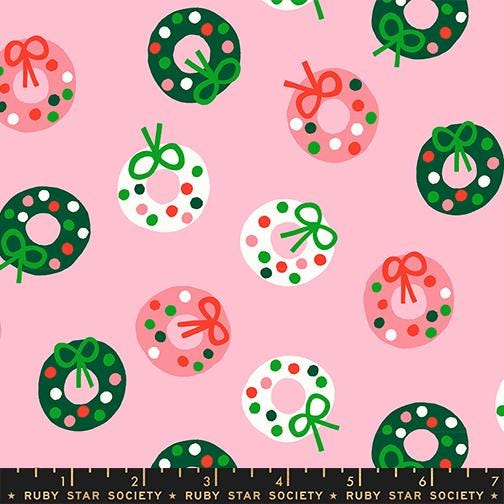 a repeating pattern of Christmas wreaths and donuts on a pink background.