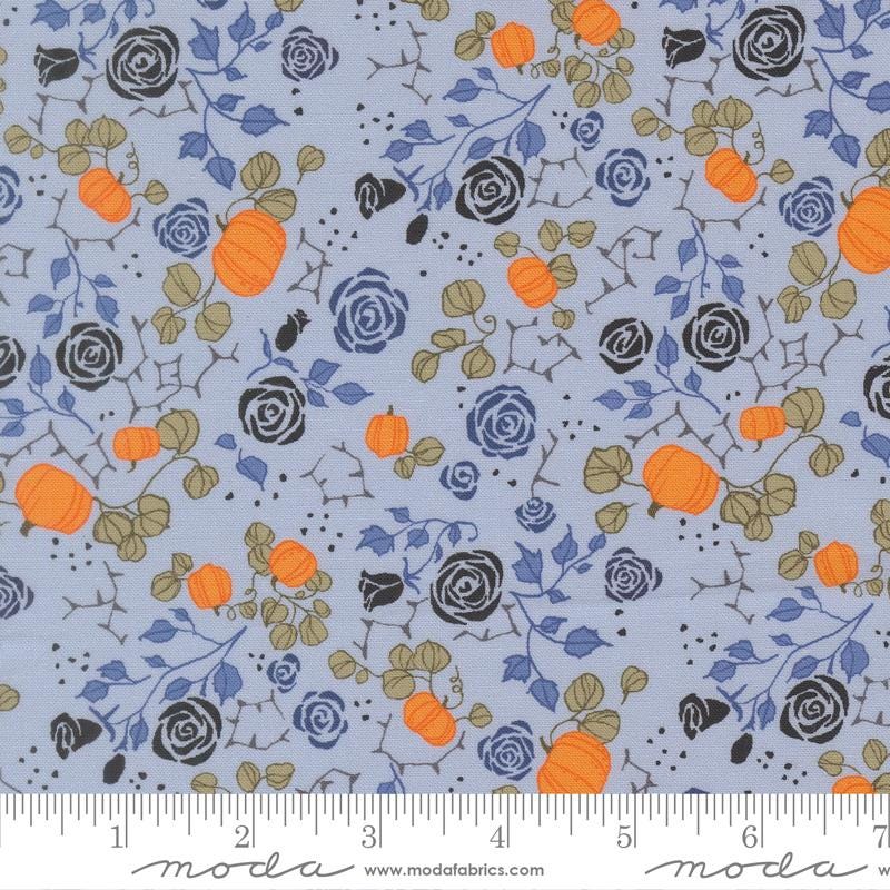 The image is a fabric with a floral pattern featuring orange pumpkins, black roses, and green leaves. The pattern is repeated across the fabric, creating a visually appealing and intricate design.