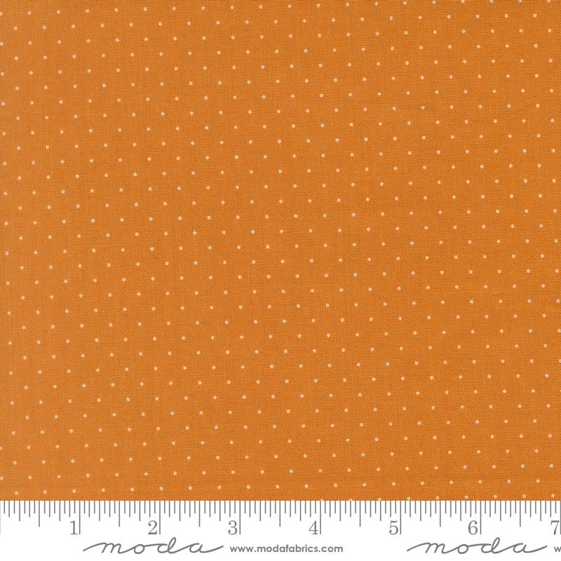 The image is a close-up of a fabric with a polka dot pattern, featuring a gradient of orange and white colors.