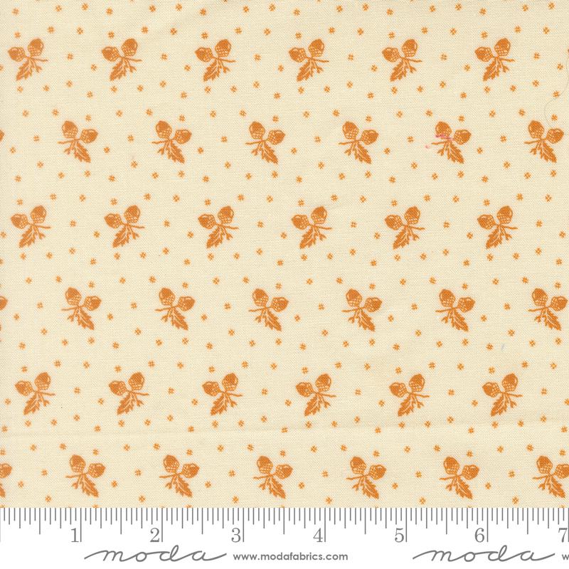 a repeating pattern of orange acorns on a cream-colored background.