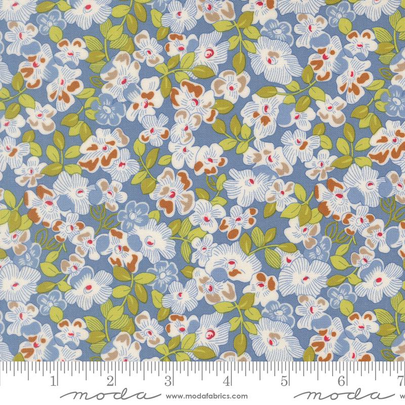 The image is a close-up of a fabric with a floral pattern in shades of blue, green, and white. The pattern consists of various flowers and leaves, creating a visually appealing and intricate design.