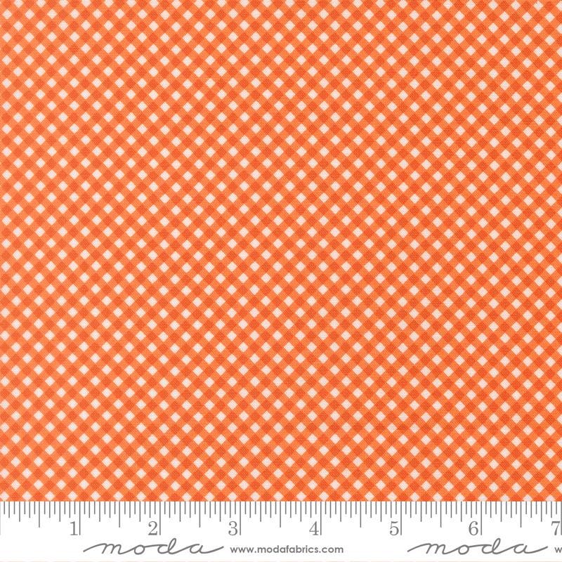 a repeating pattern of orange and white checkered squares on a fabric surface.