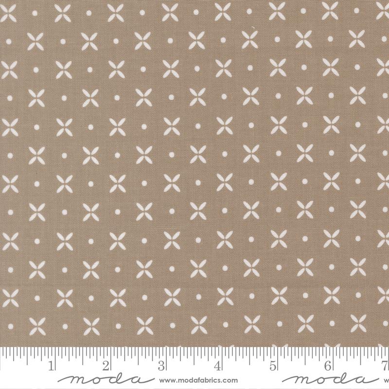 The image is a fabric with a repeating pattern of white crosses and dots on a beige background.