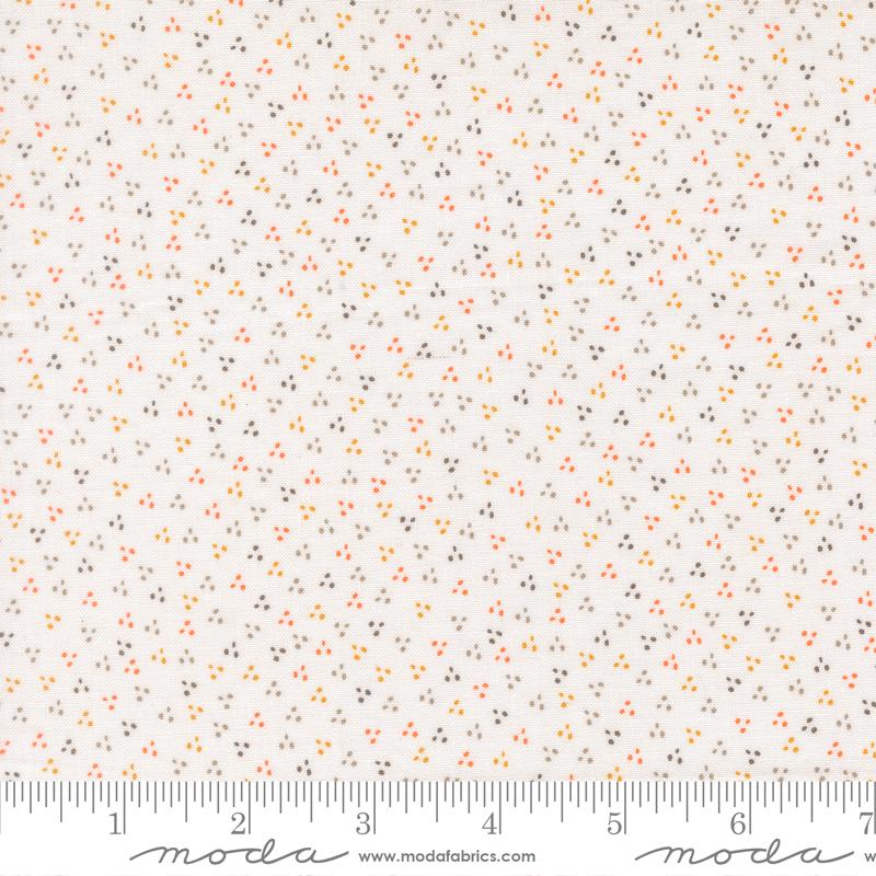 The image is a fabric with a small, multicolored dot pattern.