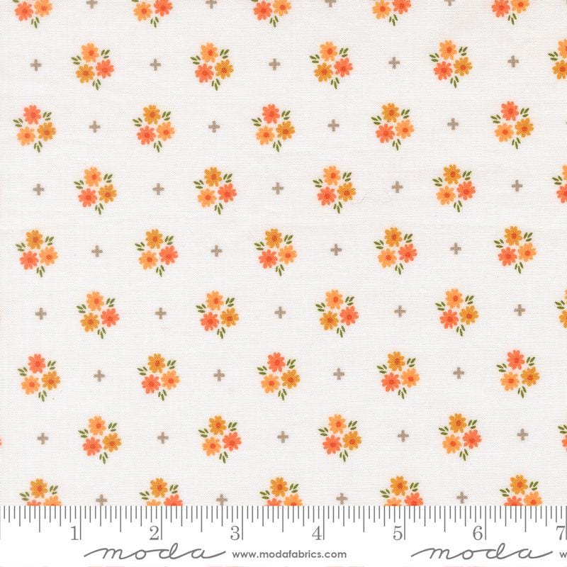 a repeating pattern of small orange flowers on a white background, with a ruler for scale at the bottom.