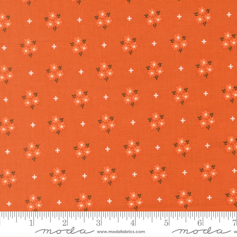 The image is a fabric with a repeating pattern of orange flowers and white stars on it. The pattern is evenly spaced and covers the entire fabric.