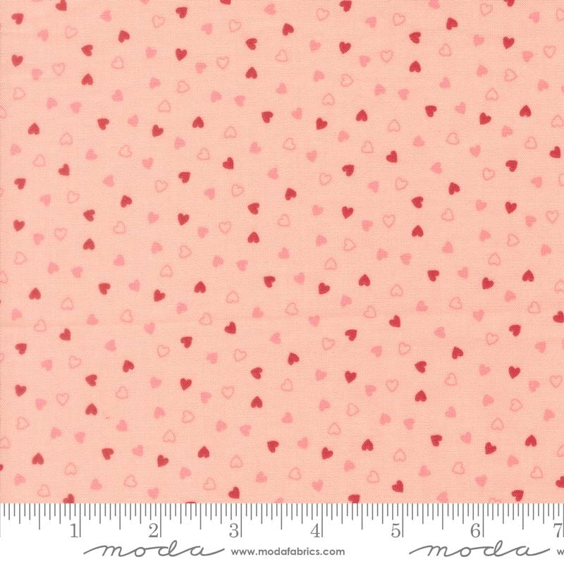 a fabric with a repeating pattern of small hearts in shades of pink and red. The pattern is spread across the fabric, creating a visually appealing and vibrant design.