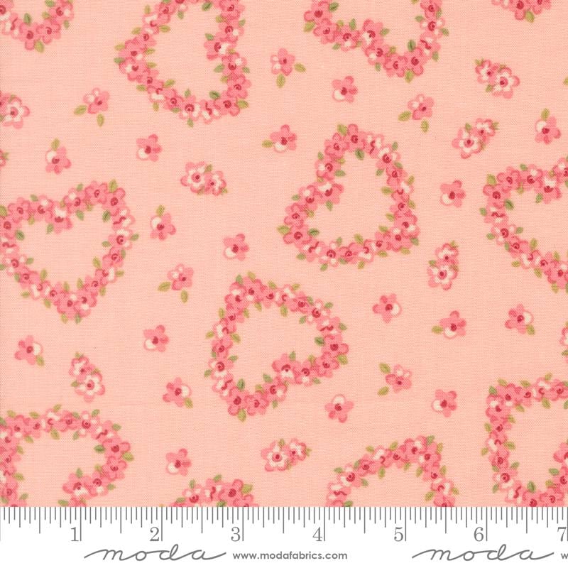 a fabric with a repeating pattern of pink hearts and flowers on a peach background.