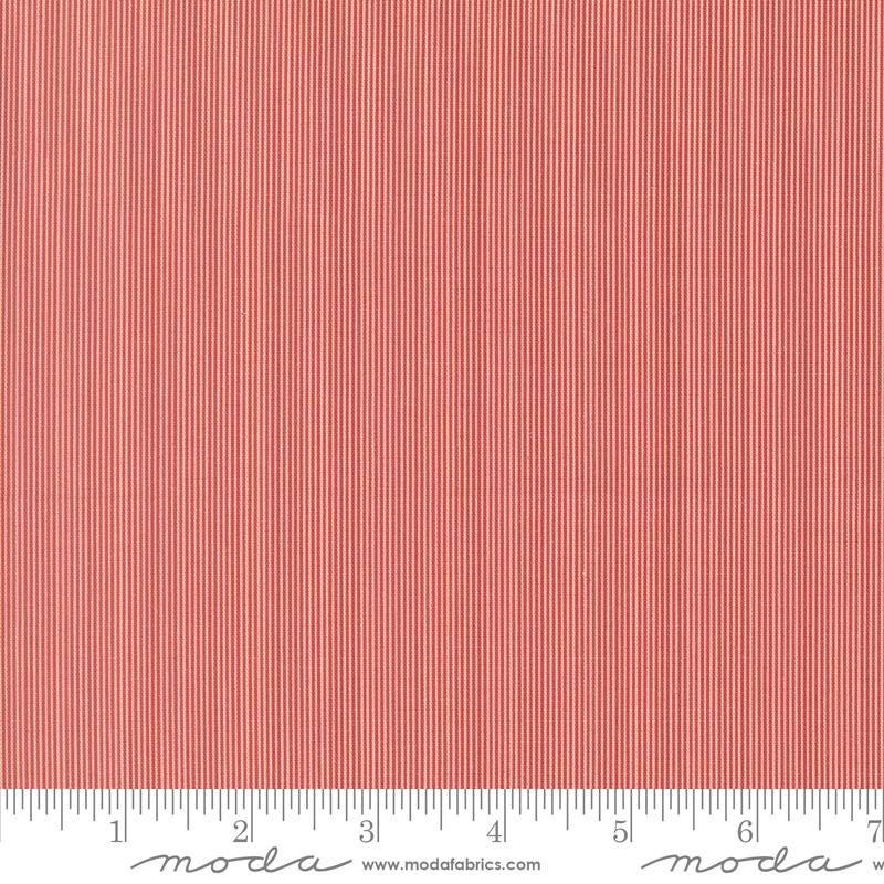 The image is a close-up of a red and white striped fabric, with a ruler for scale at the bottom.
