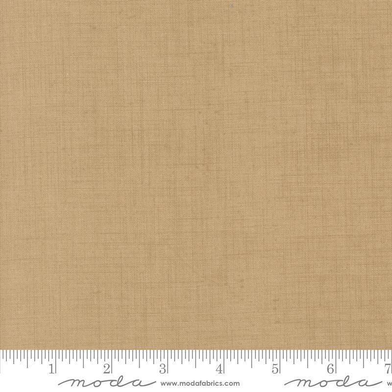 The image is a close-up of a fabric with a light brown or beige color. There is a ruler at the bottom of the image, indicating the size of the fabric in inches.